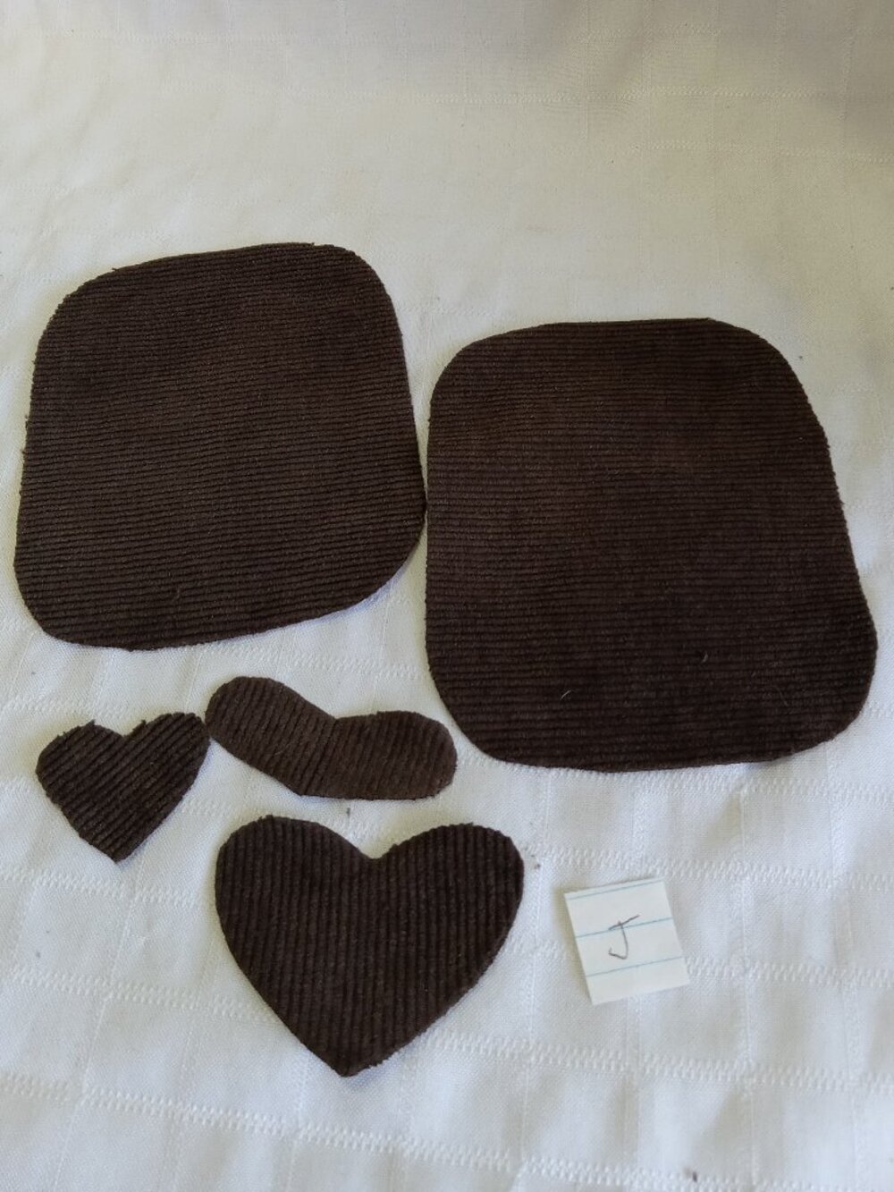 Two handmade elbow patches for sewing made of brown corduroy with hearts